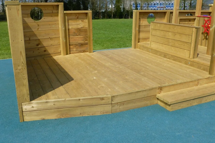 The spacious wooden deck of the Boat Stage outdoor play equipment in a school playground.