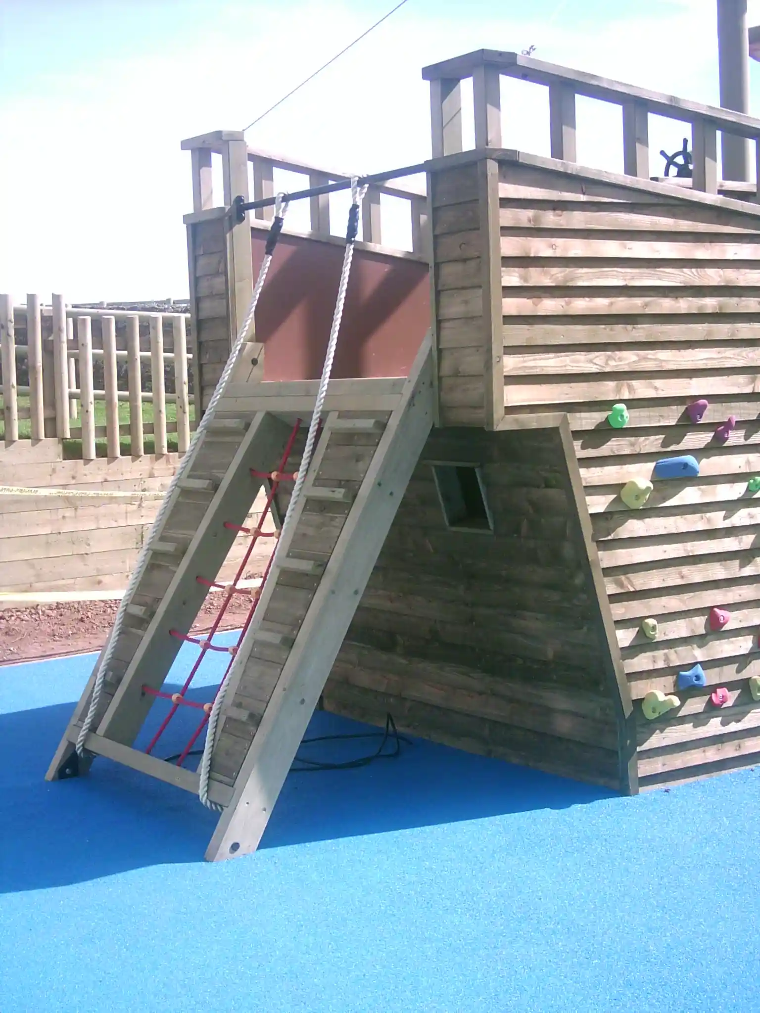 The stern of The Coverack Queen pirate ship play equipment, showing the gangplank and a climbing wall.
