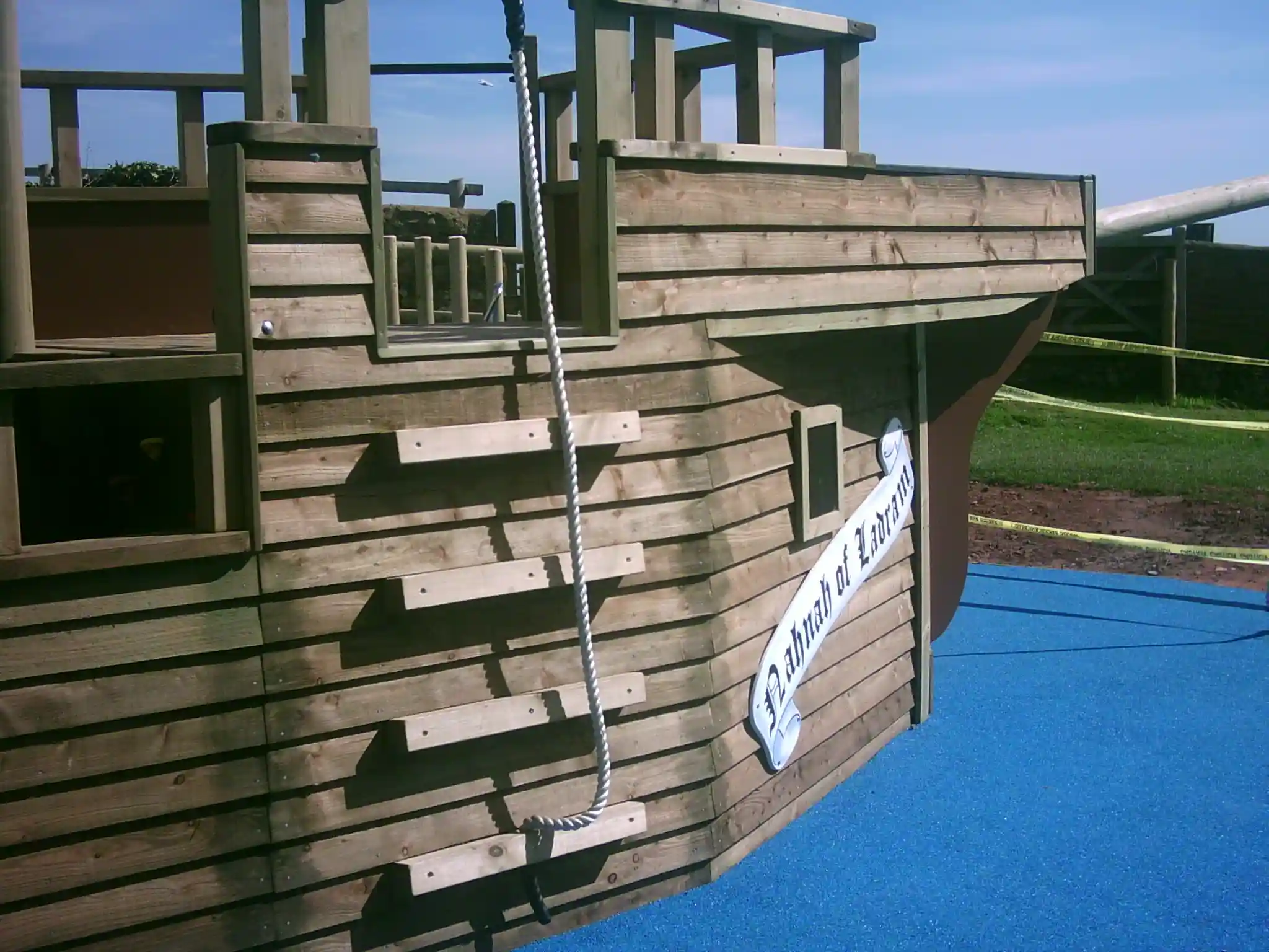 The bow of The Coverack Queen wooden pirate ship, featuring a rope ladder for climbing, in an outdoor playground.