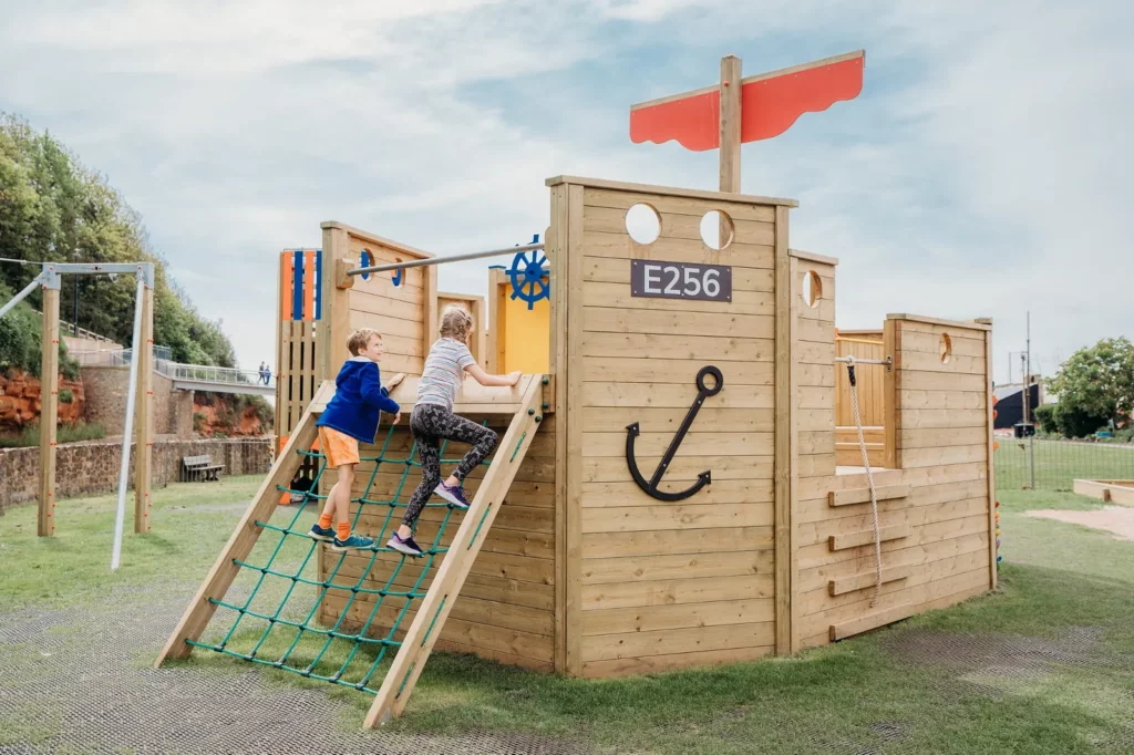 Children climbing wall on Martha D wooden playground boat