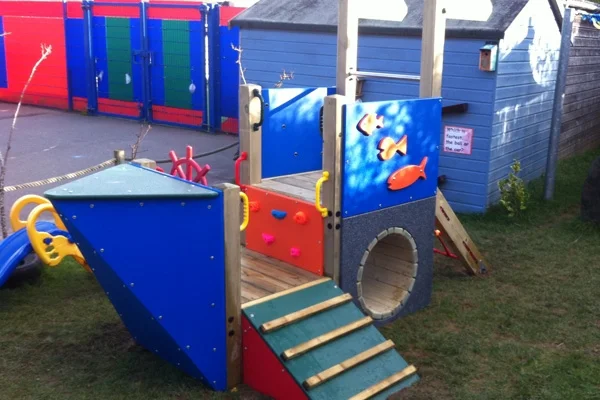 A close-up of the Trenance Trawler children's playground boat, focusing on the tunnel and climbing unit.