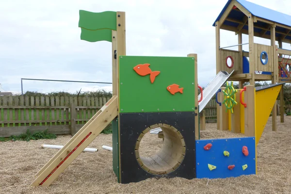 Side view of the Trenance Trawler kids' outdoor play ship, showing the climbing wall and slide.