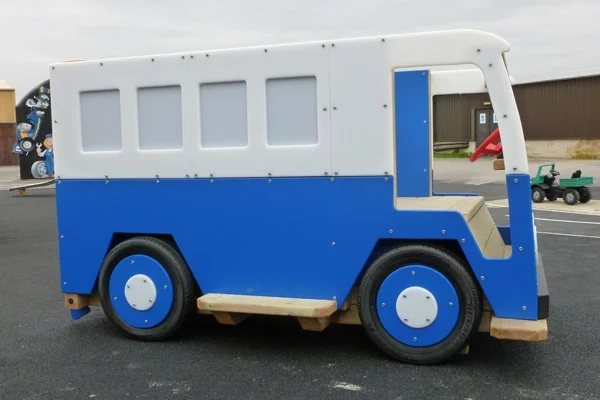 A side view of a blue and white Veedub camper van slide play structure in an outdoor playground.