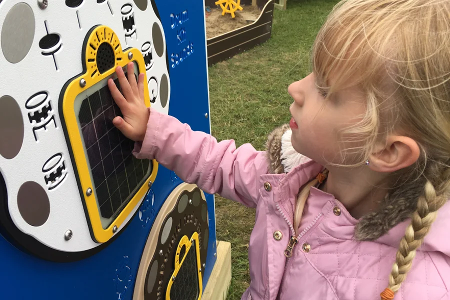 Timber solar play panel integrated into outdoor wooden playground equipment for educational activities